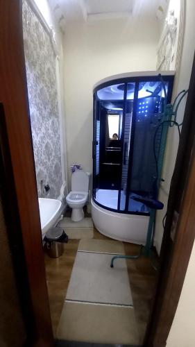 a bathroom with a tub and a sink and a toilet at UYUT INN Hotel in Samarkand