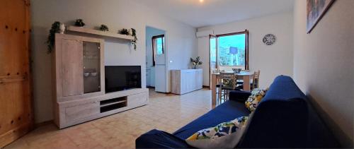 a living room with a blue couch and a television at LE CASETTE DI FLAVIA - Trinacria, Oasi Marina, il Tesoro dell'Etna in Roccalumera