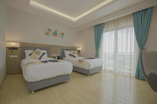 a hotel room with two beds and a window at Stay Easy Plus Hotel in Addis Ababa