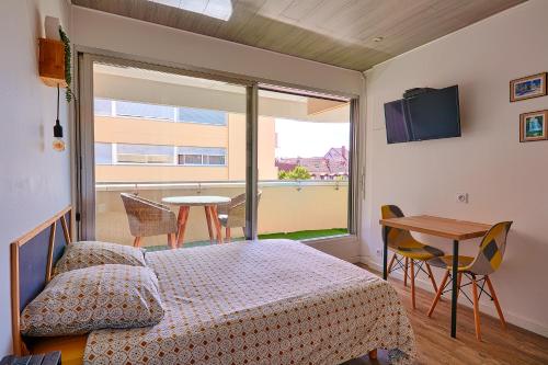 Schlafzimmer mit einem Bett, einem Tisch und einem Fenster in der Unterkunft Le moulin vieux in Pontarlier