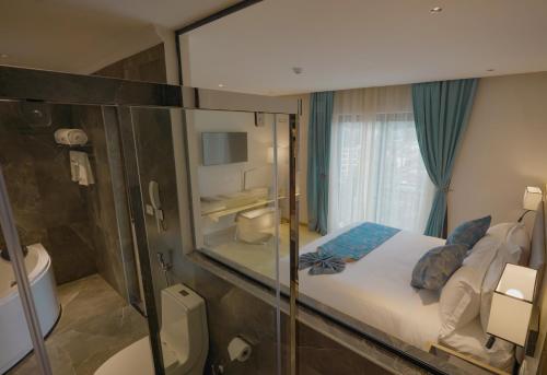 a bedroom with a large glass window and a bed at Stay Easy Plus Hotel in Addis Ababa