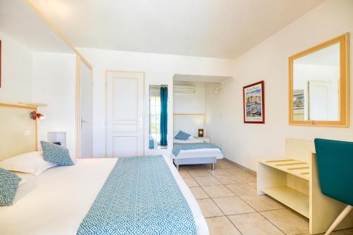 サント・マキシムにあるHôtel La Nartelleのベッドと鏡が備わるホテルルーム