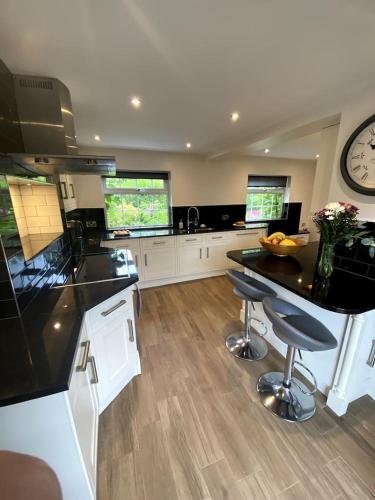 a large kitchen with a counter and a clock at Creamore Grove Wem Shrewsbury in Wem