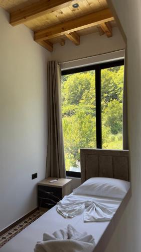 a bedroom with a bed and a large window at Hotel Nemercka & Outdoor Sports Center in Përmet