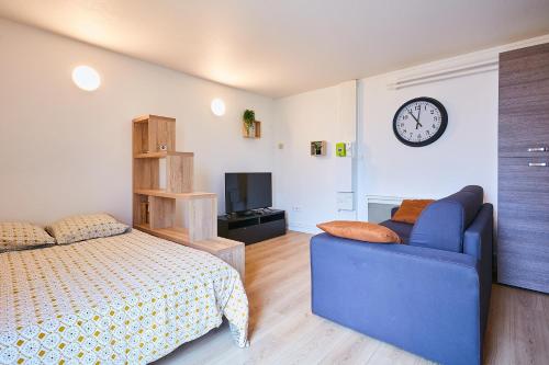 une chambre avec un lit et une horloge au mur dans l'établissement L'indépendant - place de parking - wifi, à Pontarlier