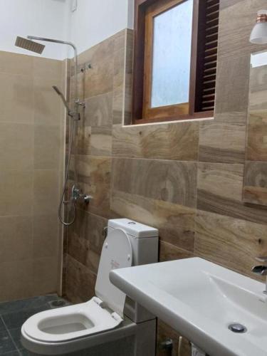 a bathroom with a toilet and a sink at Hermitage Villa in Kandy