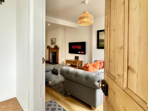 a living room with a couch and a tv at The Annex - central Helmsley with parking in Helmsley