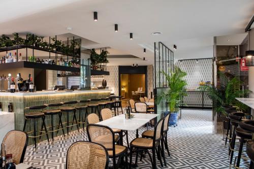 a restaurant with tables and chairs and a bar at Acta CITY47 in Barcelona