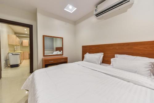 ein Schlafzimmer mit einem großen weißen Bett und einem Spiegel in der Unterkunft La Casa Apartment in Riad