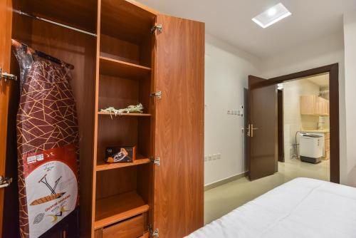 een slaapkamer met een bed en een houten kast bij شقق مسكن ايار - Ayar Residence in Riyad
