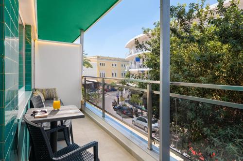 a balcony with a table and chairs and a view of a city at Lampraki Luxury Apartments in Rhodes Town