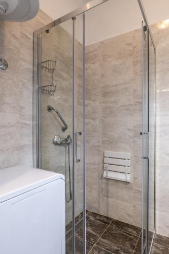 a shower with a glass door in a bathroom at Apartman Tonči Bruno - obnovljen 2026 sa novim dvorištem in Pag
