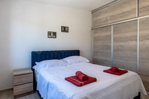 a bedroom with two red towels on a bed at Apartman Tonči Bruno - obnovljen 2026 sa novim dvorištem in Pag