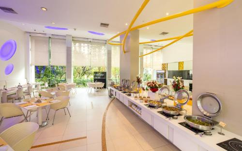 un restaurante con una línea de buffet con mesas y sillas en Hotel Kohinoor Elite near BKC en Bombay