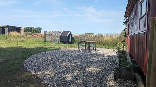 a couple of tables sitting on top of a gravel field at Under Valnødden in Stubbekøbing