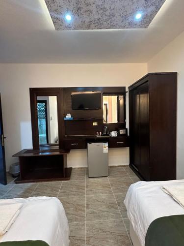 a hotel room with two beds and a flat screen tv at Petra Guests Hotel in Wadi Musa