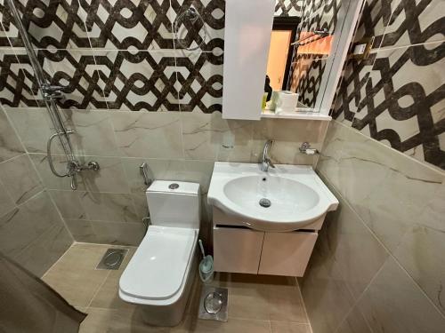 a bathroom with a toilet and a sink at Petra Guests Hotel in Wadi Musa