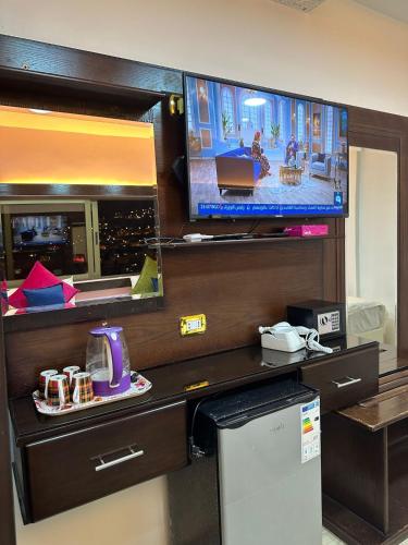 a room with a tv on a wall with a counter at Petra Guests Hotel in Wadi Musa