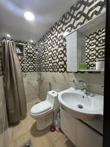 a bathroom with a white toilet and a sink at Petra Guests Hotel in Wadi Musa