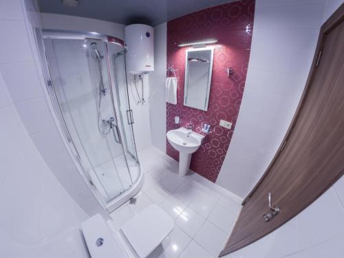 a bathroom with a shower and a toilet and a sink at APART HOTEL ORBI in Batumi