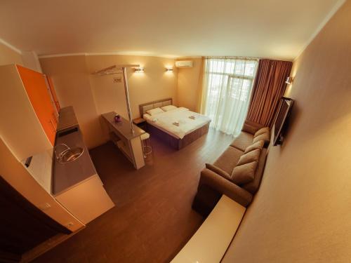 um pequeno quarto com uma cama e um sofá em APART HOTEL ORBI em Batumi