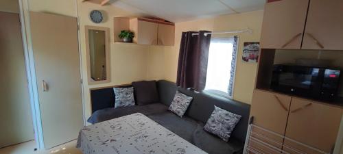 una pequeña sala de estar con sofá en una caravana en Pause Dordogne Ambiance Cozy à Sarlat, en Sarlat-la-Canéda