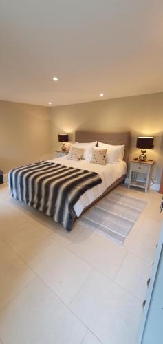 um quarto com uma cama grande e um cobertor preto e branco em Garden flat em Bath
