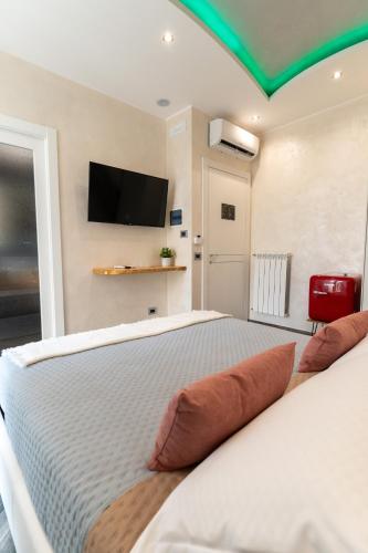 a bedroom with a bed with a flat screen tv on the wall at Suites Matteotti 57 in Civitavecchia