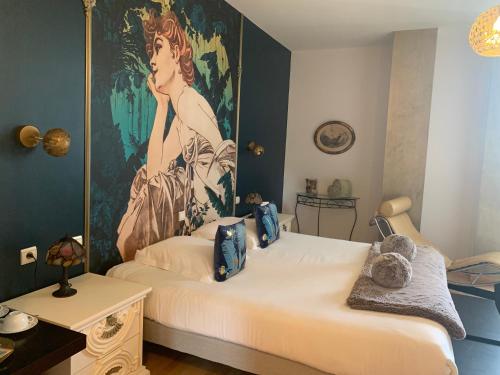 une chambre avec un lit avec un tableau sur le mur dans l'établissement Hôtel Vintage, à Quimperlé