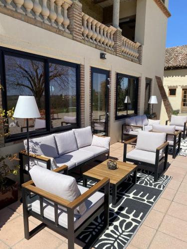 a patio with couches and tables and windows at Aux Coteaux d'Aussac in L Honor De Cos