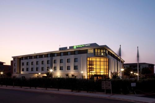 a white building with a sign on top of it at Holiday Inn Express Toulouse Airport by IHG in Blagnac