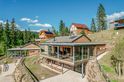 a house on top of a hill with glass at Brandlalm Chalets in Gundisch