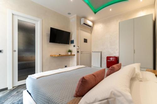 a bedroom with a bed and a tv on the wall at Suites Matteotti 57 in Civitavecchia