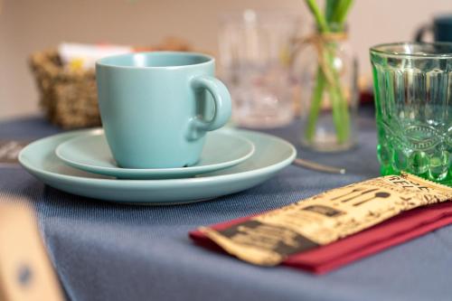 a table with a cup and a plate and a napkin at Suites Matteotti 57 in Civitavecchia