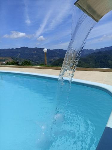 a stream of water pouring into a swimming pool at Pousada Linda Vista in Domingos Martins