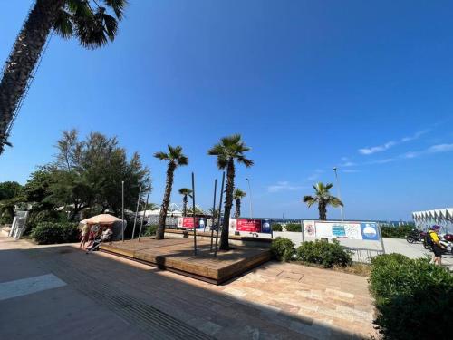 un parc avec des palmiers et l'océan en arrière-plan dans l'établissement FRONTE MARE Appartamentino per soste relax o di lavoro o di sport, à Civitanova Marche