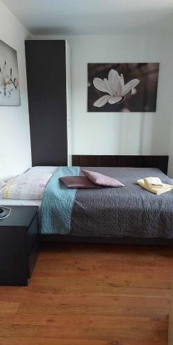 a bedroom with a bed and a painting on the wall at Apartmány Liptov in Liptovský Mikuláš