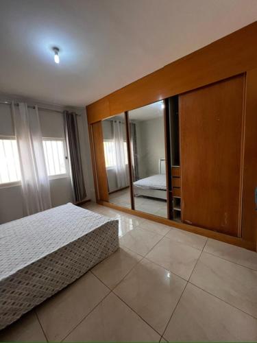 a bedroom with a bed and a large mirror at Hellen Apartament in Praia
