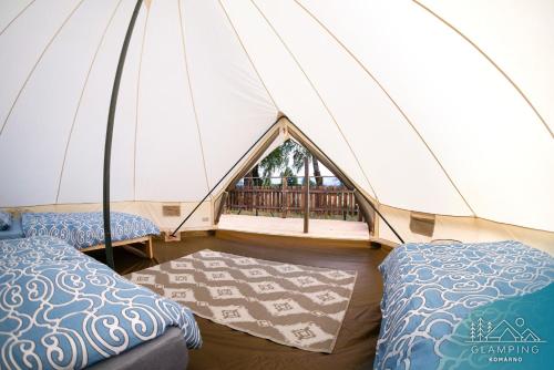 a tent with two beds and a rug at Glamping Komarno in Jelenia Góra