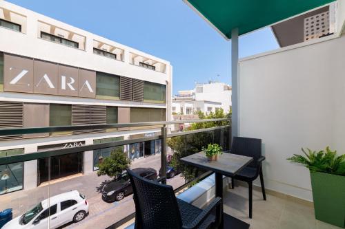 a balcony with a table and chairs on a building at Lampraki Luxury Apartments in Rhodes Town