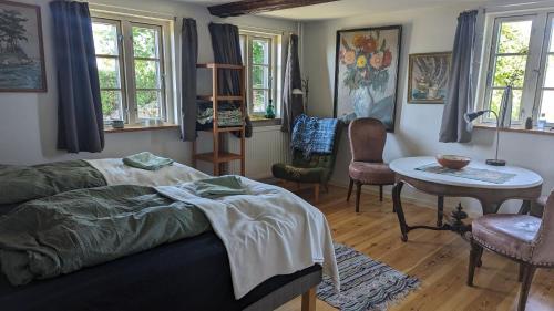1 dormitorio con 1 cama, mesa y sillas en Under Valnødden en Stubbekøbing