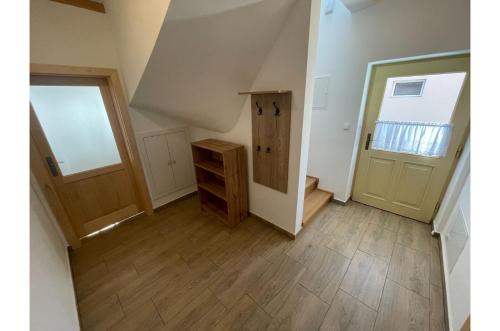 an empty hallway with a door and a wooden floor at Apartmán Borovanské baroko in Borovany