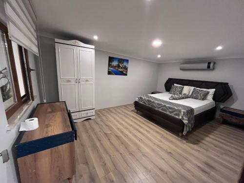 een slaapkamer met een bed en een houten vloer bij Bayraktar apart in Pelitli
