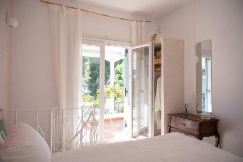a bedroom with a bed and a door to a balcony at Odyssey Suites in Poros