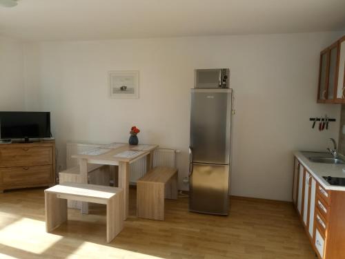 a kitchen with a stainless steel refrigerator and a table at Apartmány Liptov in Liptovský Mikuláš