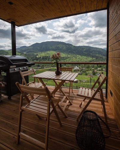 a wooden table and chairs on a deck with a grill at Krasnyk Resort in Krasnik