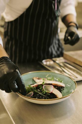 a person holding a plate of food on a counter at SOULSISTERS' Hotel 4 Sterne Superior in Kaprun