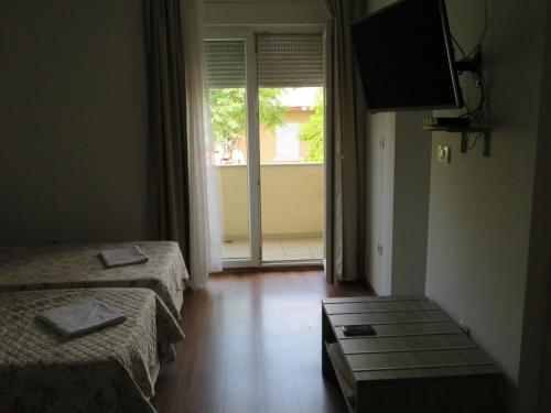 Habitación con 2 camas, TV y ventana. en Split Apartments Beta, en Split
