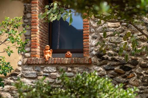 a window with two figurines sitting on a window sill at La Corte di Lurago in Lurago D'Erba 