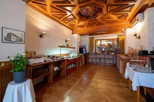 a large room with a kitchen with wooden ceilings at Hotel Munsch Restaurant & Wellness, Colmar Nord - Haut-Koenigsbourg in Saint-Hippolyte